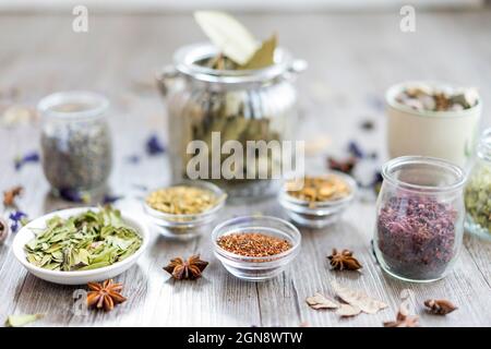Gewürze und Kräuter im Glas und in einer Schüssel Stockfoto