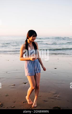 Glückliche junge Frau genießt am Strand während des Urlaubs Stockfoto