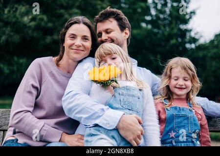 Lächelnde Familie sitzt zusammen auf der Bank Stockfoto