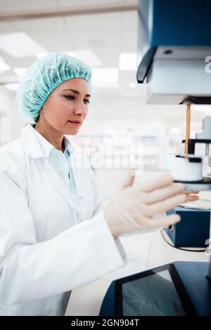 Weibliche Profi mit Mikroskop während der Arbeit im Labor Stockfoto