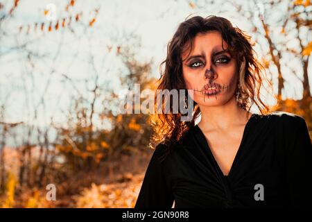 Junge Frau mit gruseligen Halloween Make-up im Wald Stockfoto