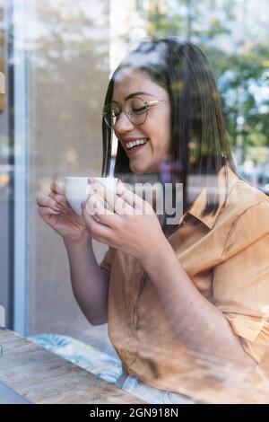 Glückliche junge Geschäftsfrau beim Kaffee im Café Stockfoto