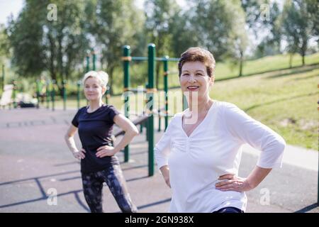 Frauen mit der Hand an der Hüfte trainieren im Park Stockfoto