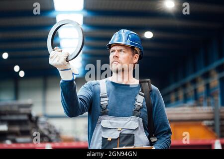 Männlicher Geschäftsführer, der mit Fachleuten aus der Industrie zusammen steht Stockfoto