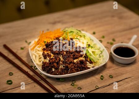 Traditionelles chinesisches Gericht, Nudeln mit würzigem Schweinefleisch und Gemüse Stockfoto