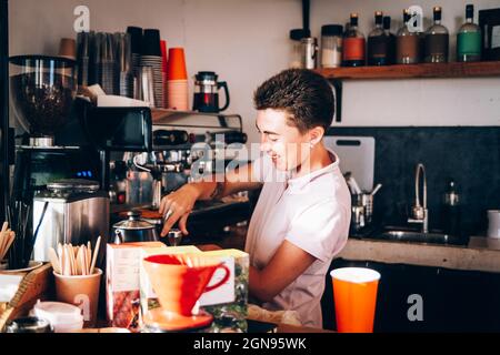 Barista bereitet Kaffee zu, während sie im Café arbeitet Stockfoto