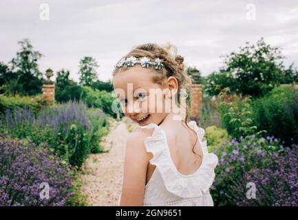 Junge Blumenmädchen lächeln auf eine Hochzeit in einem schönen Feld von Blumen Stockfoto