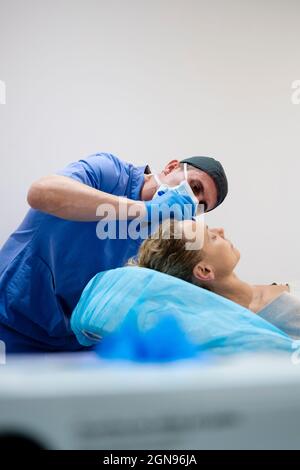 Chirurg zeichnet Linie auf Mädchen Auge mit Marker Vorbereitung für das Verfahren. Stockfoto