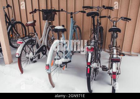 Fahrräder im Winter mit Schnee bedeckt. Schneebedeckte Fahrräder und Boden. Wintersaison mit starkem Schneefall Stockfoto