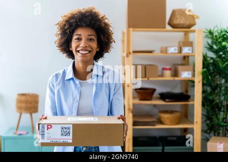 Junge Frau scannt Barcode des Pakets im Studio Stockfoto
