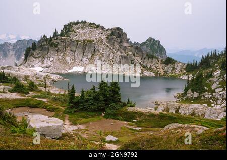 Alpensee, umgeben von Bäumen und Granitfelsen entlang des pct Stockfoto