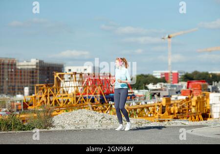 Junge Frau beim Joggen auf der Baustelle Stockfoto