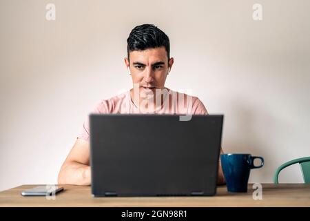 Freiberufliche Tätigkeit in legerer Kleidung, bei der Unterhaltung beim Surfen auf dem Laptop und bei der Arbeit an einem Projekt Stockfoto