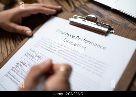 Person, die ein Formular zur Leistungsbeurteilung des Mitarbeiters ausfüllt Stockfoto