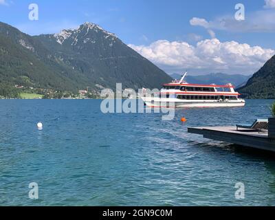 Die traditionelle Fähre überquert das Wasser des türkisfarbenen Achensees in Tirol Stockfoto