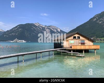 Das hölzerne schwimmende Haus und die Fähre auf dem smaragdgrünen Achensee in Österreich Stockfoto