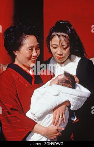 Japan. Tokio-Stadt. Zwei Frauen mit einem Baby im Freien. Stockfoto