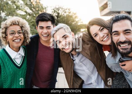 Porträt von glücklichen jungen, vielfältigen Freunden, die Spaß im Freien haben - Fokus auf Hipster-Mann Gesicht Stockfoto