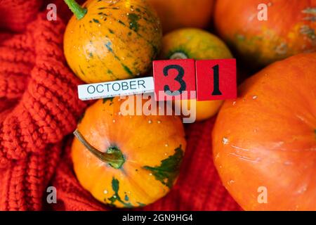 Holzwürfelkalender zeigt am 31. Oktober Halloween die Vorbereitung von Kürbissen zum Schnitzen. Feiertags- und Partykonzept Stockfoto