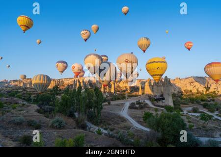 Kappadokien, Türkei - 14. September 2021: Panoramablick auf bunte Heißluftballons, die am Himmel gegen die Felsenformatio fliegen oder fliegen Stockfoto