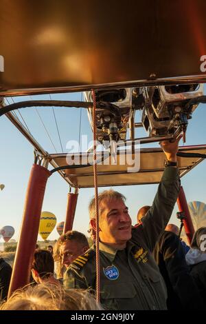 Kappadokien, Türkei - 14. September 2021: Ein Heißluftballonpilot navigiert seinen Ballon durch den Himmel in der Nähe von Goreme in der Region Kappadokien in der Türkei. Stockfoto