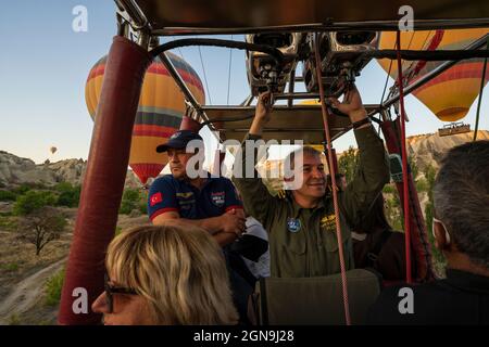 Kappadokien, Türkei - 14. September 2021: Ein Heißluftballonpilot navigiert seinen Ballon durch den Himmel in der Nähe von Goreme in der Region Kappadokien in der Türkei. Stockfoto