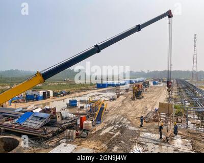 Ölindustrie. Sortierung von Bohrwerkzeugen, Rohren nach Durchmesser, Neuverlegung. Arbeiten mit einem Kran. Stockfoto