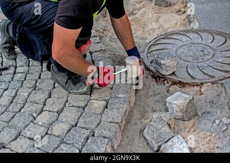 Betonfertigung und Pflastersteinlegung - Außenbearbeitung von Der Standort in der Nähe des Hauses - Austausch von Asphalt Stockfoto