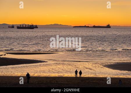 English Bay Sundown Vancouver. Frachter ankerten in English Bay. Im Hintergrund sind die Hügel von Vancouver Island zu sehen. Vancouver, British Columbia, C Stockfoto