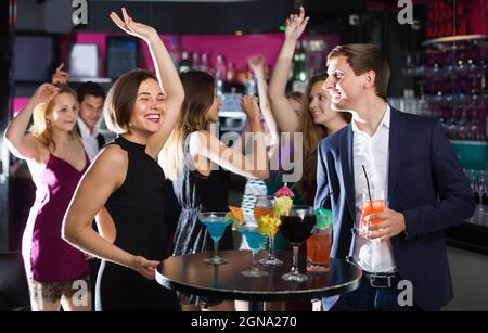Kollegen tanzen auf Corporate Party mit Cocktails in Händen Stockfoto