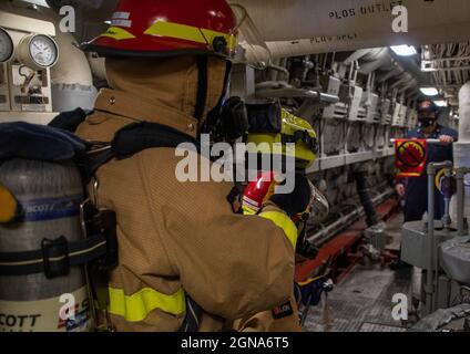 PAZIFISCHER OZEAN (31. August 2021) – Seeleute führen während einer Brandübung an Bord des Amphibientransportschiffes USS Portland (LPD 27) am 31. August ein simuliertes Feuer der Klasse Bravo im Hauptmaschinenraum durch. Portland, Teil der USS Essex Amphibious Ready Group (ARG), zusammen mit der 11. Marine Expeditionary Unit (MEU), Ist im Verantwortungsbereich der 7. Flotte der USA tätig, um die Interoperabilität mit Verbündeten und Partnern zu verbessern und als einsatzbereite Einsatztruppe für den Frieden und die Stabilität in der Indo-Pazifik-Region zu dienen. (USA Navy Foto von Mass Communication Specialist 2nd Class Devin Kates) Stockfoto