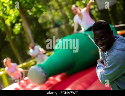 Froher afroamerikanischer Mann, der versucht, Weibchen zu werfen Stockfoto