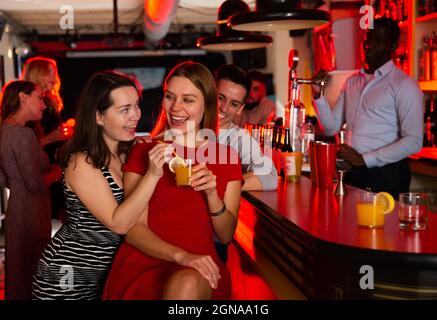 Freundinnen haben Spaß und trinken Cocktails auf der Party in der Bar Stockfoto