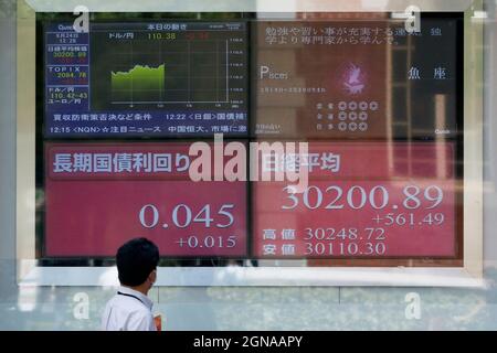 Tokio, Japan. September 2021. Ein Mann mit Gesichtsmaske sieht auf eine elektronische Börse, die den japanischen Nikkei-Aktiendurchschnitt zeigt, der um 561.49 Punkte auf 30200.89 Punkte gestiegen ist. (Bild: © Rodrigo Reyes Marin/ZUMA Press Wire) Bild: ZUMA Press, Inc./Alamy Live News Stockfoto