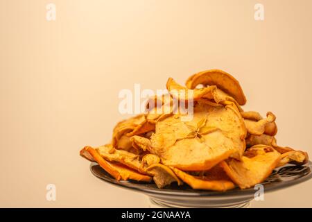 Getrocknete Früchte auf einem Teller. Getrocknete Äpfel auf warmem Hintergrund in Scheiben geschnitten. Stockfoto