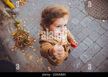 Kleines Mädchen, das eine rote Blume in der Hand hält Stockfoto