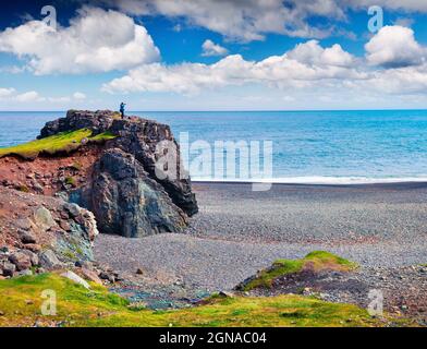 Typische isländische Meereslandschaft mit schwarzem Basaltsand. Fotograf auf dem Felsen fotografiert den Sommermorgen an der Westküste Islands, Europa. Kunst Stockfoto