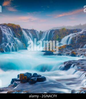 Sommer Sonnenuntergang mit einzigartigen Wasserfall - Bruarfoss. Bunte Abend Szene in South Island, Europa. Künstlerischen Stil nachbearbeitete Foto. Stockfoto