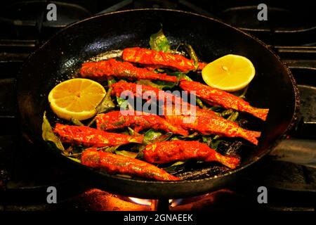 kerala-Stil masala marinierten Fisch braten, Sardinenfisch in einer Pfanne. Stockfoto