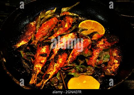 kerala-Stil Masala gewürzten Fisch braten, Sardinenfisch in einer Pfanne.Traditionelles Essen Stockfoto