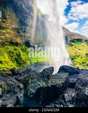 Bunte morgen in der Mitte der Kvernufoss Wasserfall. Majestic Szene in South Island, Europa. Künstlerischen Stil nachbearbeitete Foto. Stockfoto