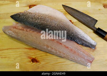 Frisches atlantisches Seebarschfilet auf einem Holzbrett in Nahaufnahme Stockfoto