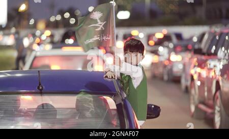 Riad, Saudi-Arabien. September 2021. Ein Kind lehnt sich aus dem Autofenster, um die nationale Feuerwerksshow am 23. September 2021 in Dammam, Saudi-Arabien, zu sehen. Quelle: Mohamed Nasr/Xinhua/Alamy Live News Stockfoto