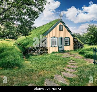 Malerische Turf-Top-Kirche im kleinen Dorf Hof. Farbenfroher Morgen in Skaftafell im Vatnajokull Nationalpark, Südostisland, Europa. Künstlerischer Stall Stockfoto