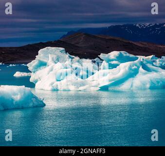 Schwimmende blaue Eisberge in der Gletscherlagune von Jokulsarlon. Dramatischer Abend im Vatnajokull Nationalpark, Südostisland, Europa. Beitrag zum künstlerischen Stil Stockfoto