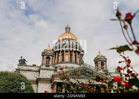 Isaakskathedrale in Sankt-Petersburg, Russland. Sityscape. Ansicht von unten nach oben. Verschwommene Blumen im Vordergrund Stockfoto