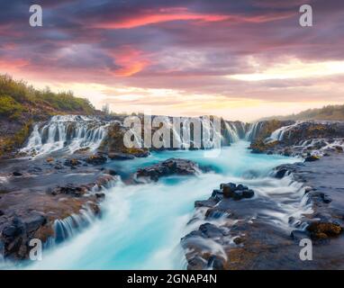 Dramatischer Sonnenuntergang im Sommer mit einzigartigem Wasserfall - Bruarfoss. Bunte Abendszene in Südisland, Europa. Künstlerisches Foto im nachbearbeiteten Stil. Stockfoto