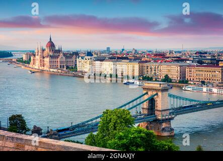 Farbenfrohe Abendansicht des Parlaments und der Kettenbrücke in der Stadt Pest. Prachtvolles Stadtbild im Frühling von Budapest, Ungarn, Europa. Postprozess im künstlerischen Stil Stockfoto