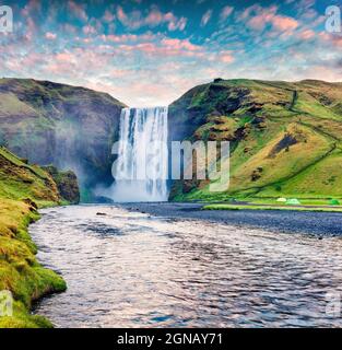 Herrlicher Sommersonnenaufgang am riesigen Skogafoss Wasserfall am Skoga Fluss. Farbenfrohe Sommerszene in Südisland, Europa. Künstlerischer Stil nachbearbeitet phot Stockfoto