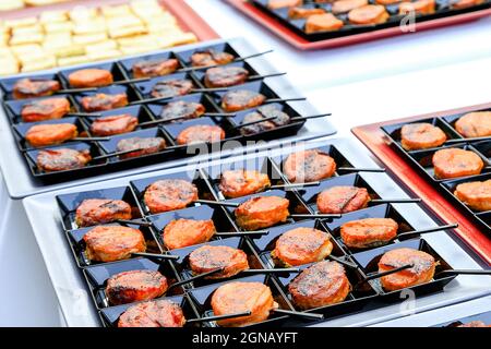 Catering Fingerfood aus der Nähe. Kleine orientalische Snacks auf quadratischen schwarzen Tellern mit winzigen Löffeln. Gourmetküche. Menü-Konzept-Bild Stockfoto